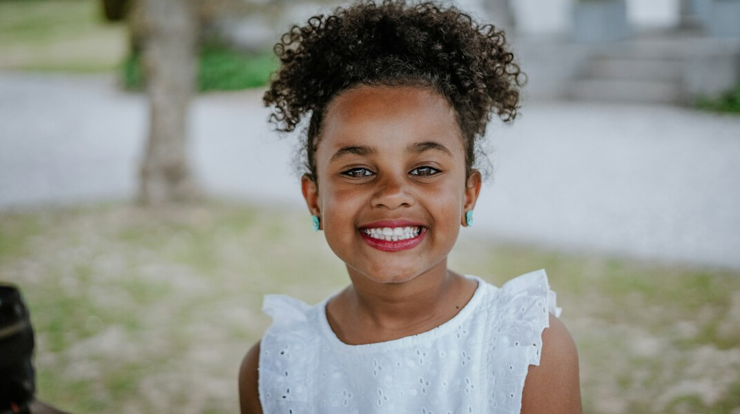 Portrait of a woman with dark curly hair smiling